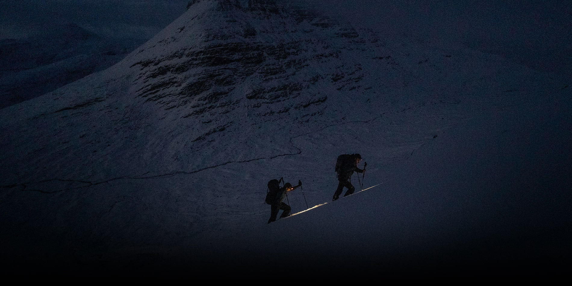 Climbing at dusk with sunset behind in Jöttnar mountain clothing